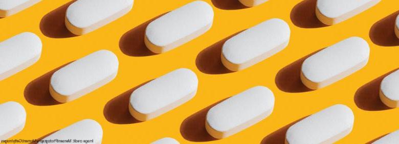 Imagen de pastillas cuidadosamente organizadas sobre fondo amarillo.